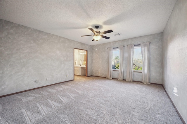 carpeted spare room with ceiling fan and a textured ceiling