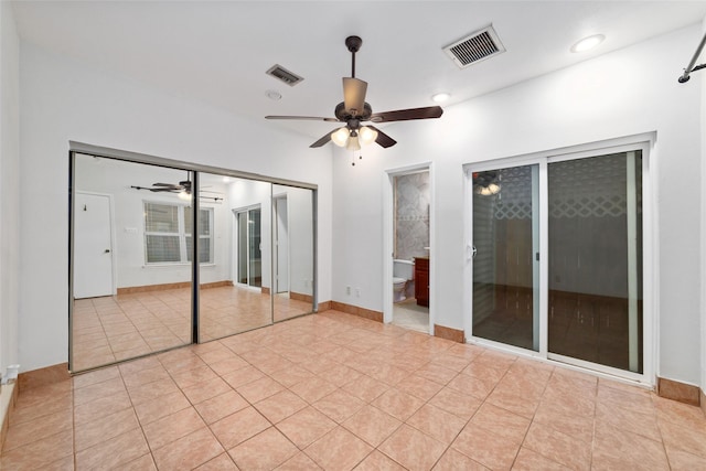 unfurnished bedroom with ensuite bath, ceiling fan, and light tile patterned floors