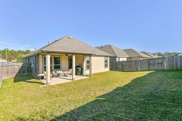 rear view of house with outdoor lounge area, ceiling fan, a yard, and a patio