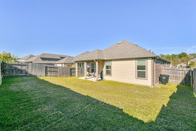 rear view of house with a patio and a lawn