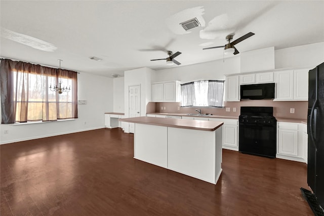 kitchen featuring black appliances, a center island, white cabinetry, and pendant lighting