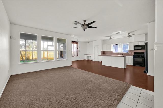 unfurnished living room featuring ceiling fan and light tile patterned floors