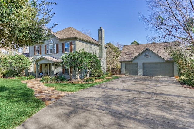 view of front of house featuring a front yard, an outdoor structure, and a garage