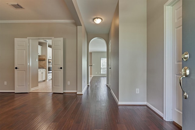 entryway featuring crown molding and dark wood-type flooring