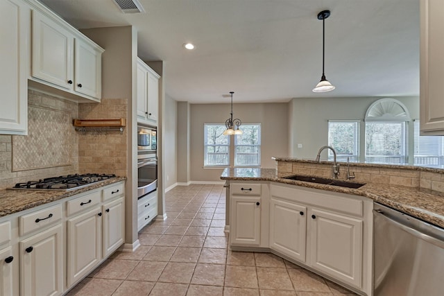 kitchen featuring white cabinets, sink, light stone countertops, and stainless steel appliances