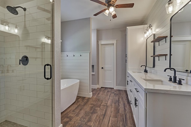 bathroom featuring plus walk in shower, vanity, wood-type flooring, and ceiling fan