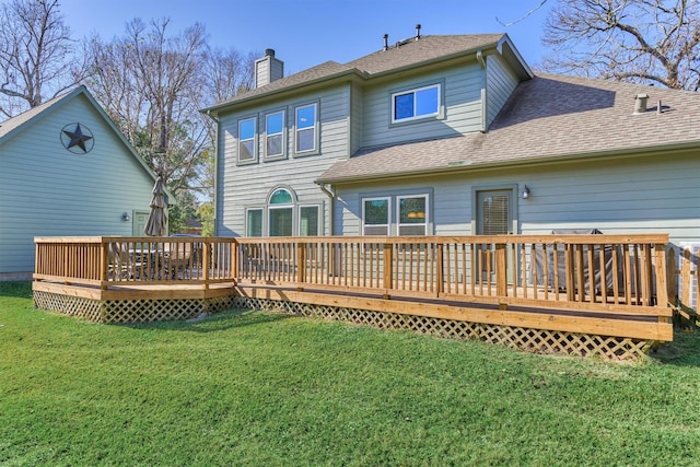 rear view of house featuring a deck and a yard