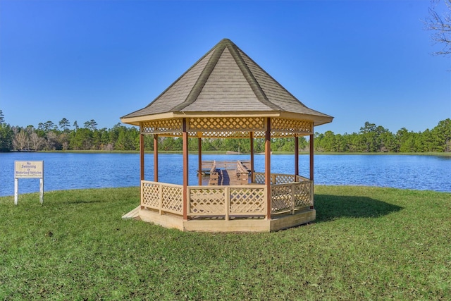 dock area with a gazebo, a yard, and a water view