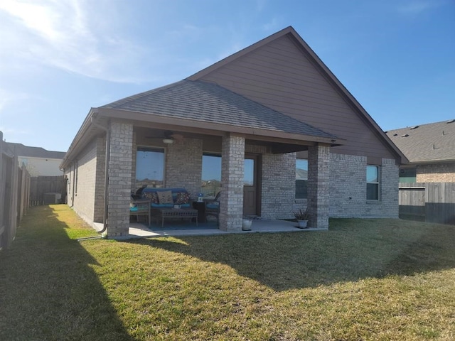 back of property with a lawn, a patio area, and an outdoor living space