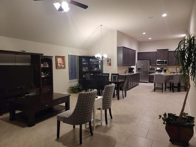 tiled dining room with ceiling fan with notable chandelier and lofted ceiling