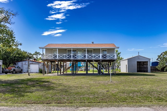 view of front of house with covered porch, a garage, an outdoor structure, and a front yard