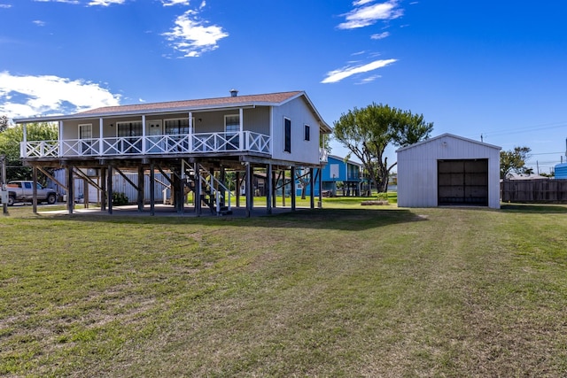 back of property with a porch, a garage, an outdoor structure, and a yard