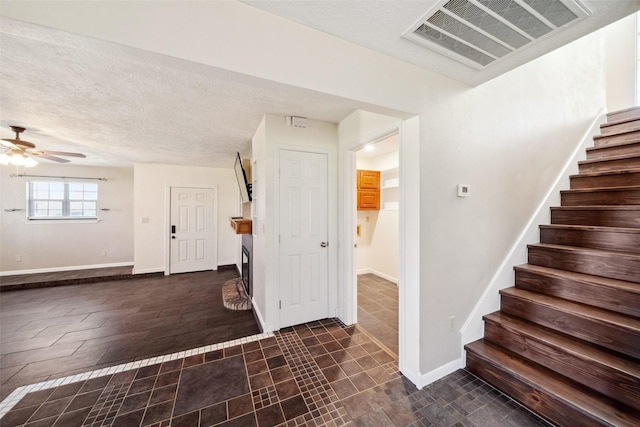 entryway featuring a textured ceiling and ceiling fan