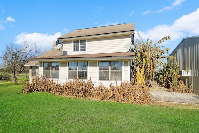 back of property featuring a lawn