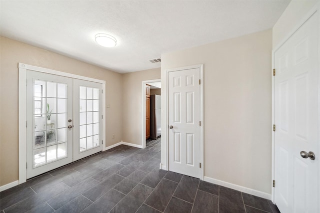 unfurnished room featuring french doors