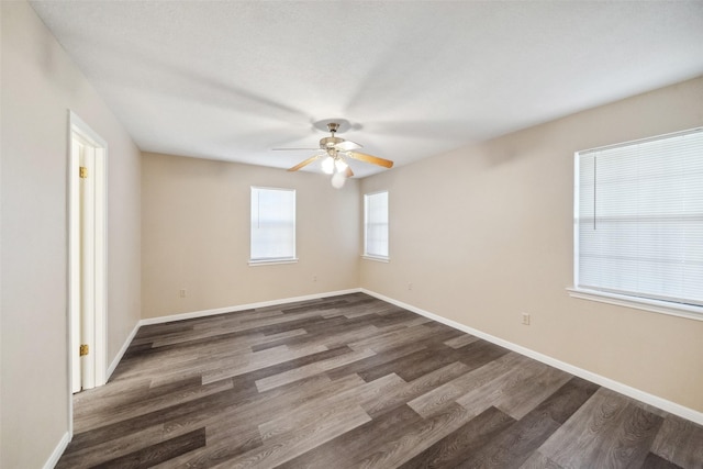 empty room with dark hardwood / wood-style flooring and ceiling fan