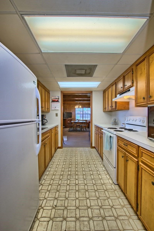 kitchen with a paneled ceiling and white appliances