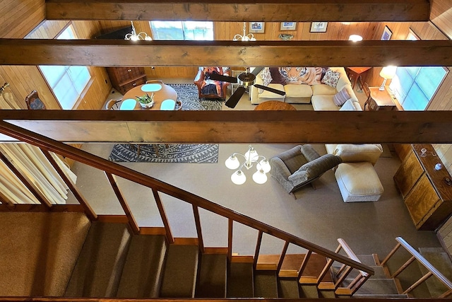 stairway with lofted ceiling and an inviting chandelier