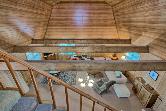 interior space with carpet flooring, a notable chandelier, vaulted ceiling, wooden walls, and wood ceiling