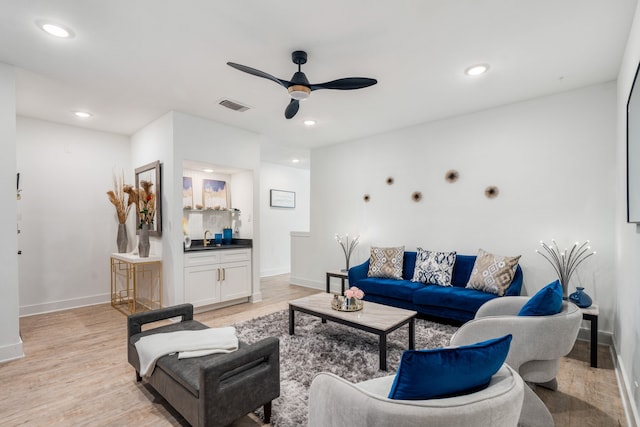 living room with light wood-type flooring and ceiling fan