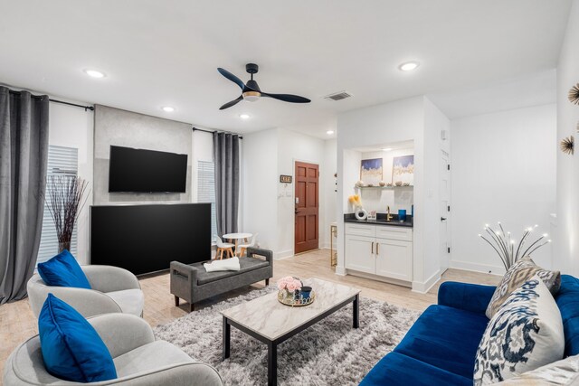 living room featuring ceiling fan and light hardwood / wood-style flooring