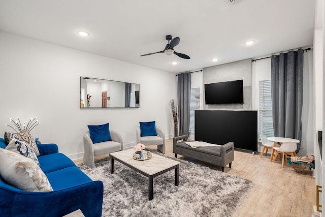 living room with ceiling fan and light hardwood / wood-style flooring