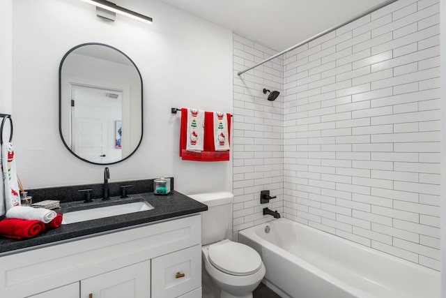 full bathroom featuring vanity, tiled shower / bath combo, and toilet