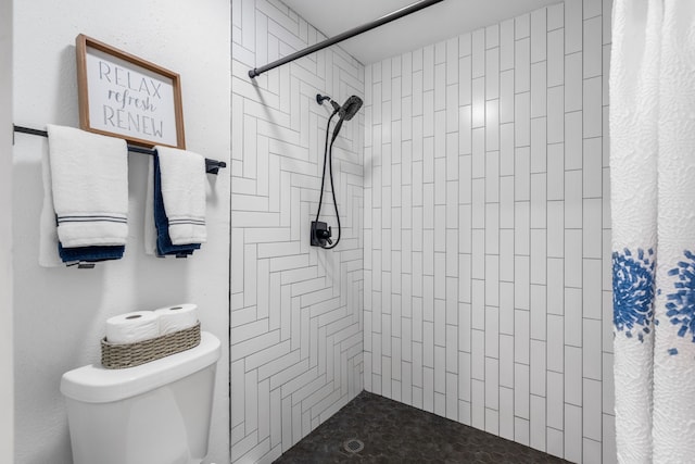 bathroom featuring a shower with shower curtain and toilet