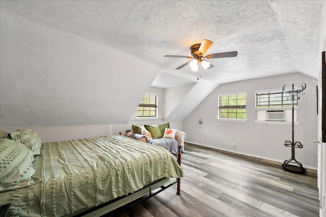 bedroom with a textured ceiling, multiple windows, and ceiling fan