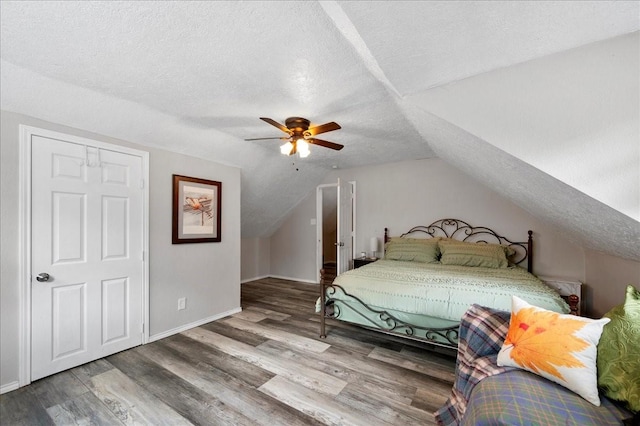 bedroom featuring ceiling fan, wood-type flooring, a textured ceiling, and vaulted ceiling