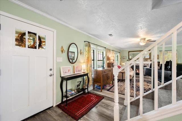 foyer entrance featuring ceiling fan, wood-type flooring, and ornamental molding