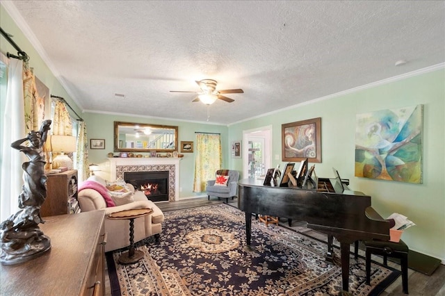 living room featuring a fireplace, hardwood / wood-style floors, a textured ceiling, and ornamental molding