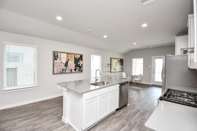 kitchen with white cabinetry, sink, stainless steel dishwasher, white fridge, and a center island with sink