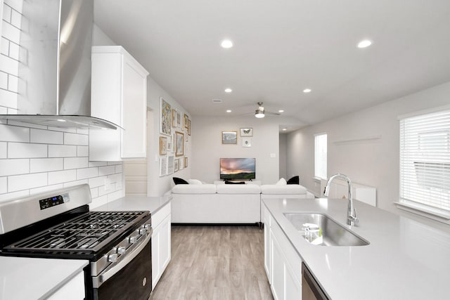 kitchen featuring backsplash, white cabinets, sink, wall chimney exhaust hood, and stainless steel appliances