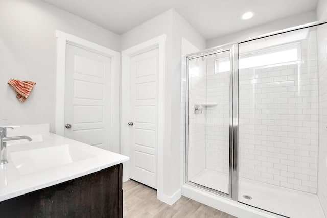 bathroom with vanity, an enclosed shower, and wood-type flooring