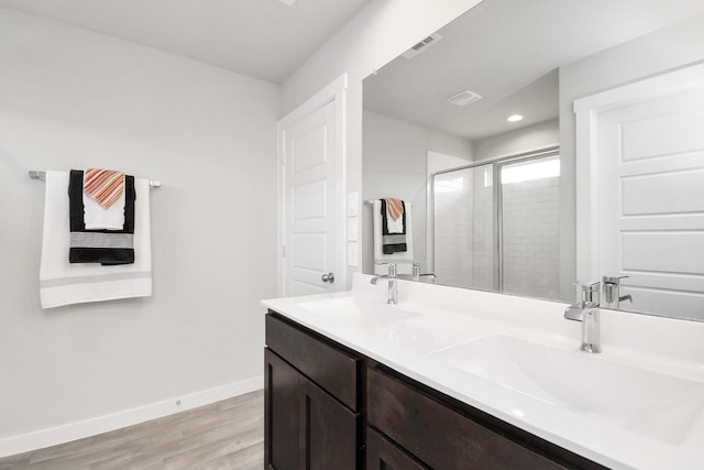 bathroom with a shower with shower door, wood-type flooring, and vanity