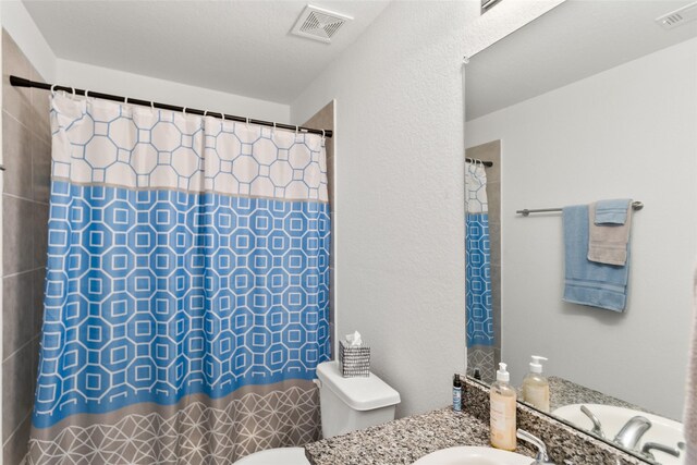 bathroom with a shower with curtain, vanity, and toilet