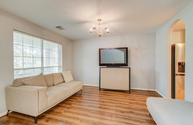 living room with light wood-type flooring and a notable chandelier