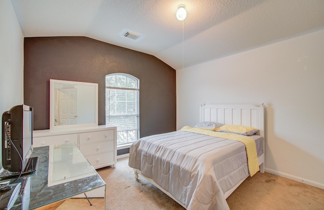 carpeted bedroom featuring a textured ceiling and lofted ceiling