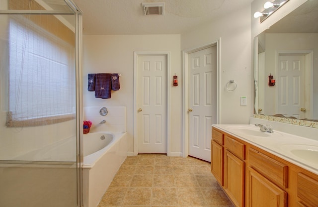 bathroom with vanity, separate shower and tub, and a textured ceiling