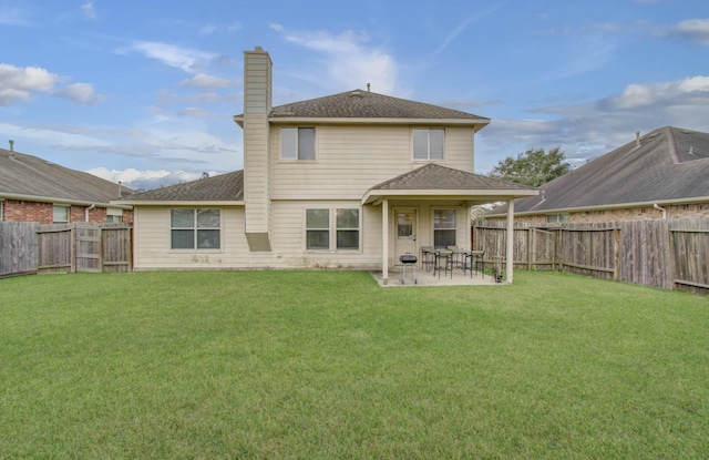 back of house with a yard and a patio