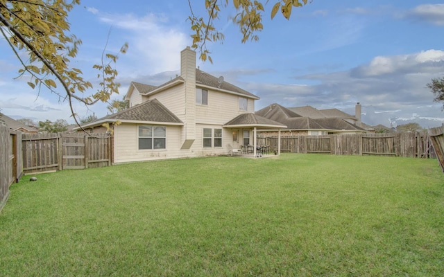 back of house featuring a yard and a patio