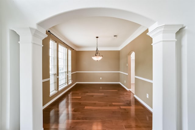 unfurnished dining area featuring dark hardwood / wood-style flooring, ornate columns, and ornamental molding