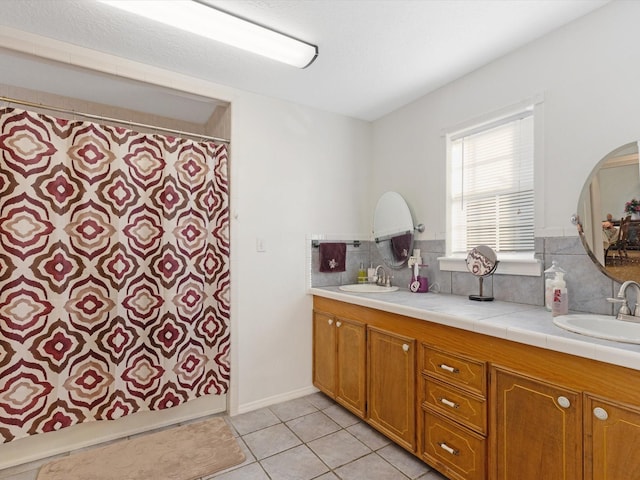 bathroom with tile patterned flooring, vanity, and tasteful backsplash