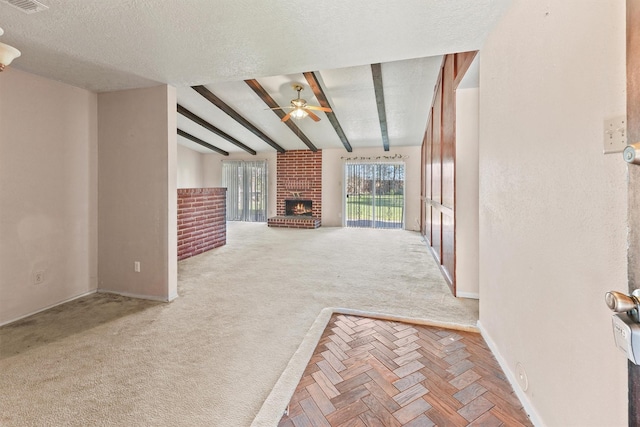 unfurnished living room featuring a brick fireplace, carpet flooring, vaulted ceiling with beams, ceiling fan, and a textured ceiling