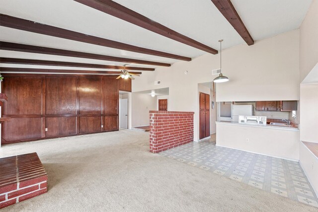 unfurnished living room with ceiling fan, beam ceiling, sink, and light carpet