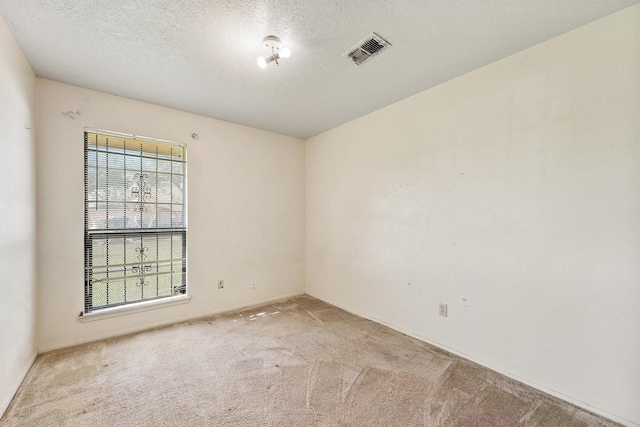 carpeted spare room featuring a textured ceiling