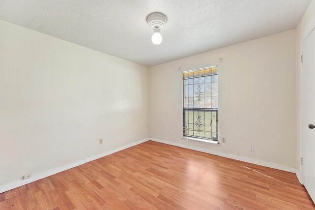 empty room featuring wood-type flooring and a textured ceiling