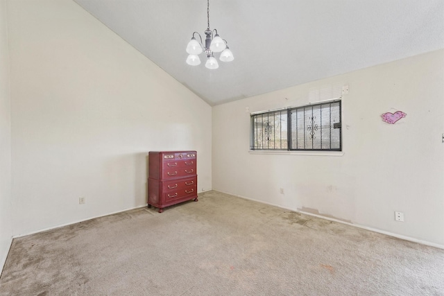 empty room with a notable chandelier, light carpet, and vaulted ceiling