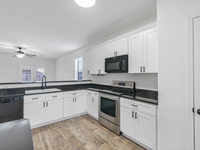 kitchen featuring black appliances, white cabinetry, and sink